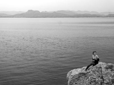 The way this woman is sitting on the rocks makes her appear like a siren. The mountains on the background are hardly visible through the haze